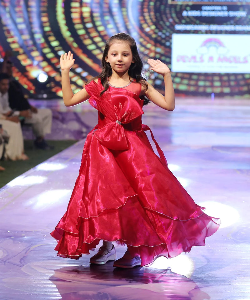 Young girl in a red gown on a stage with colorful background