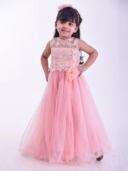 Young girl wearing a pink dress with floral details on a white background