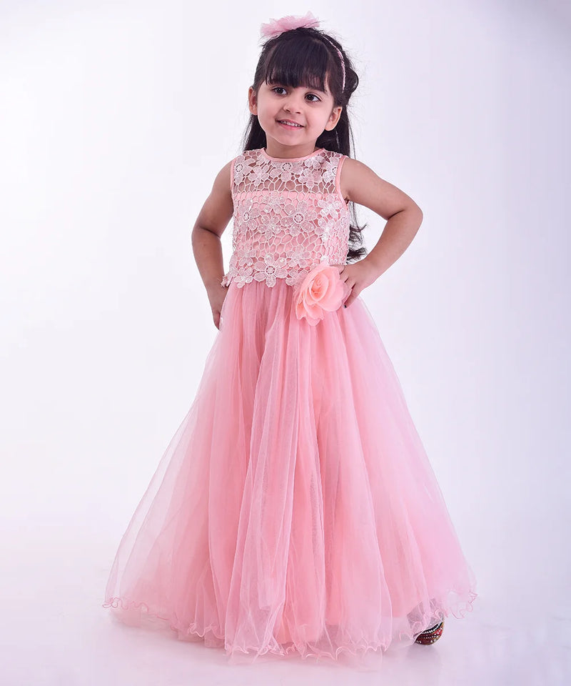 Young girl wearing a pink dress with floral details on a white background