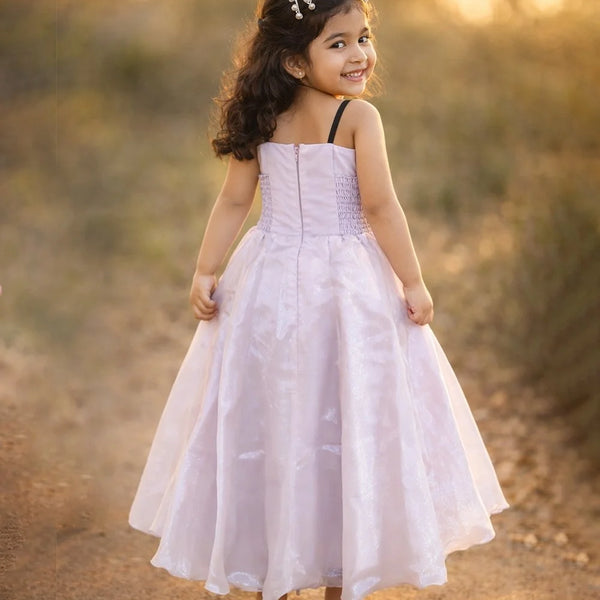 Young girl in a white dress standing in a natural setting with blurred background