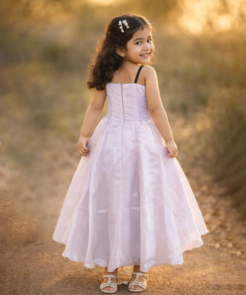 Young girl in a white dress standing in a natural setting with blurred background