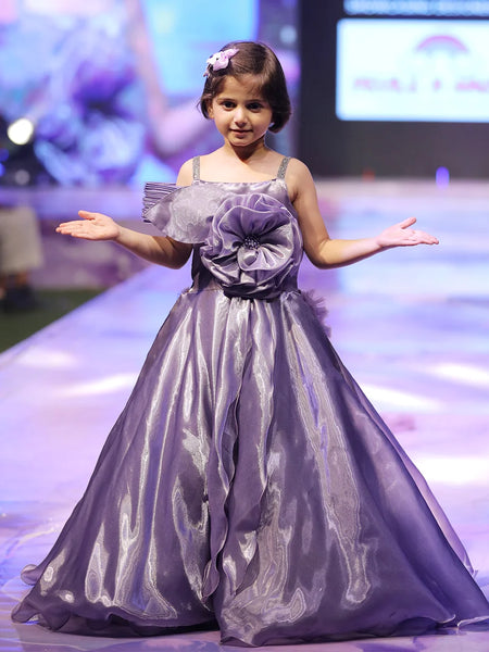 Young girl in a purple dress on a stage with a blurred background