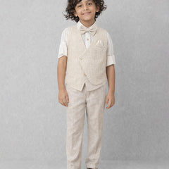 Young boy wearing a beige vest and pants set on a gray background