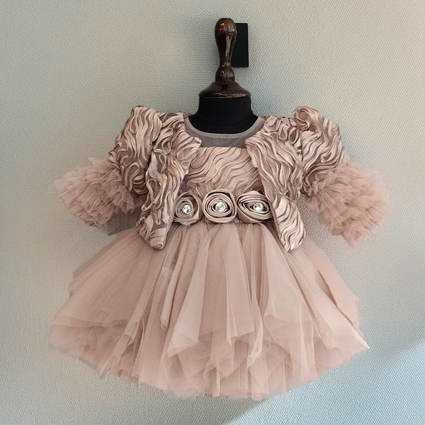 Pink dress with floral embellishments on a mannequin against a light blue background