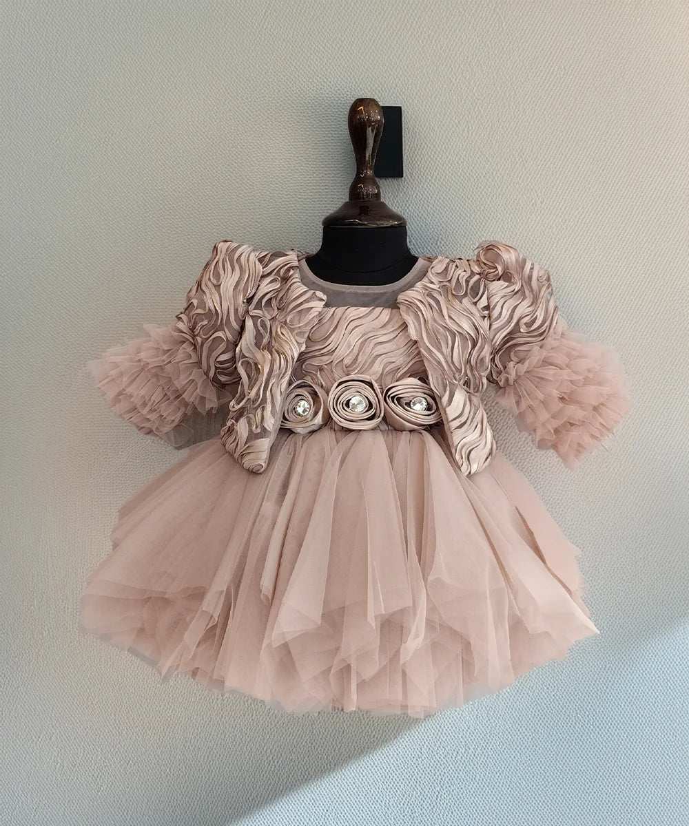 Pink dress with floral embellishments on a mannequin against a light blue background