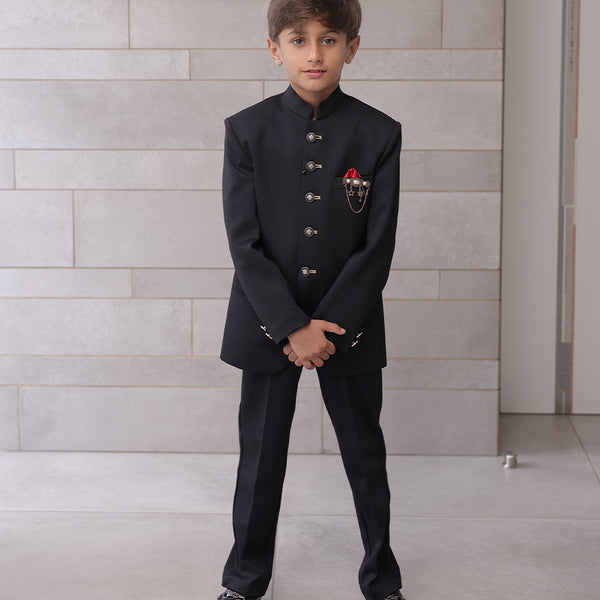  It is a black Jodhpuri suit set which consists of a Jodhpuri Coat along with matching pants. It features stylized buttons, a red coloured pocket square and a nice broach.