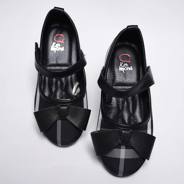 Close-up of classic check flats with black bow accent and flexible sole for girls, Jaipur