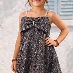Young girl wearing a sparkly dress with a blurred background