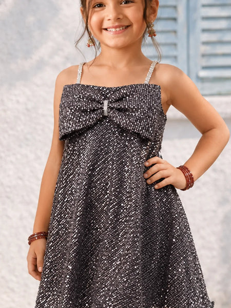 Young girl wearing a sparkly dress with a blurred background