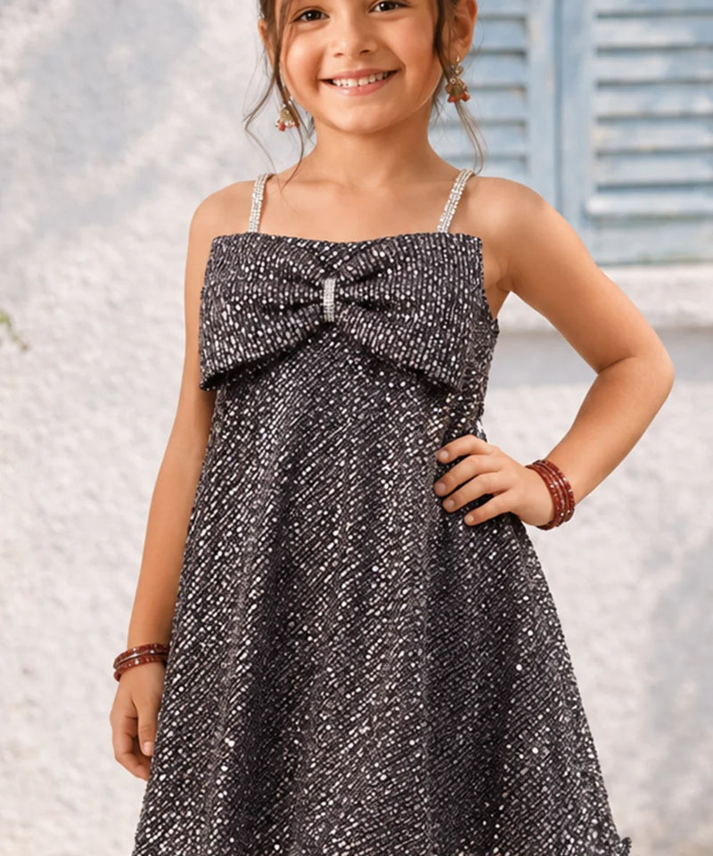 Young girl wearing a sparkly dress with a blurred background