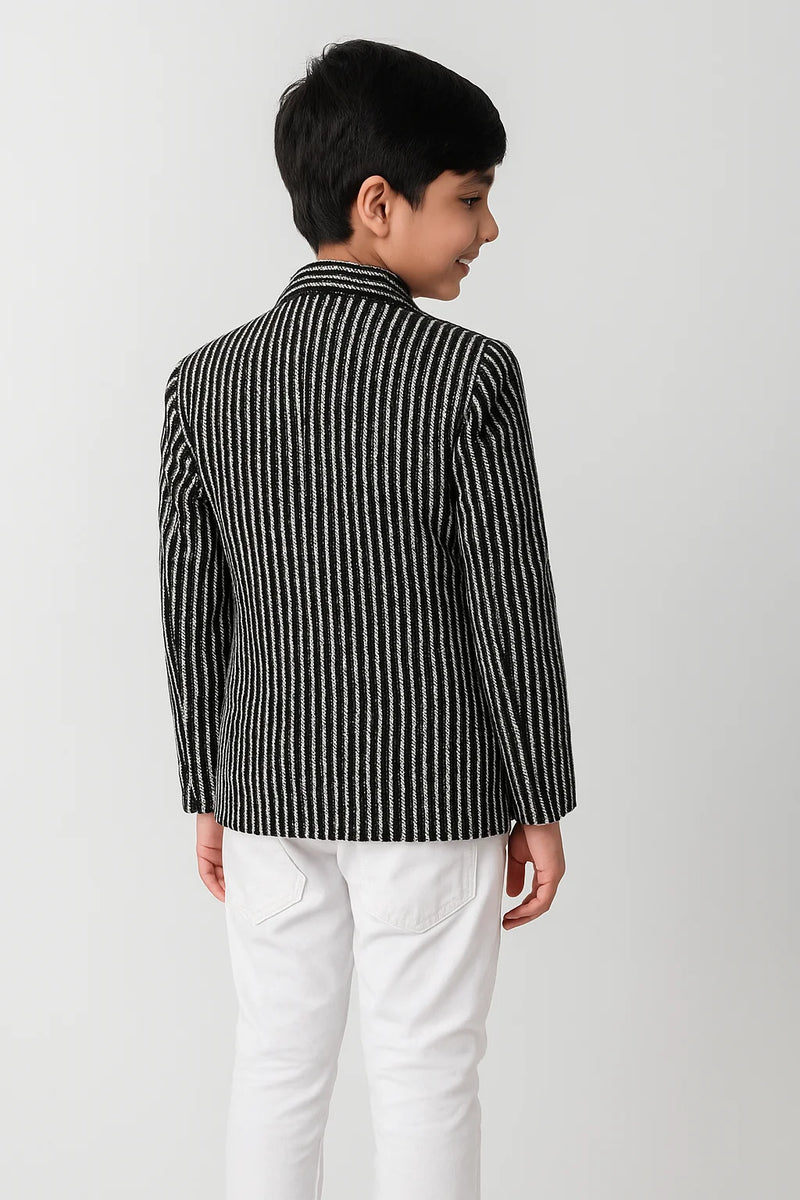 Child wearing a black and white striped shirt with a collar on a plain background