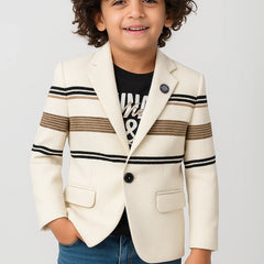 Child wearing a cream blazer with black and brown striped sleeves on a light gray background