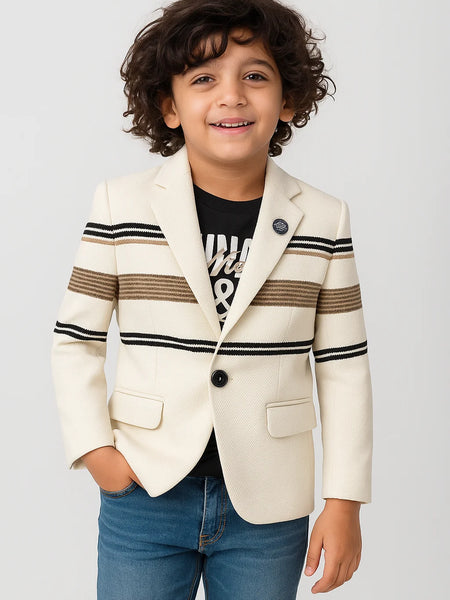 Child wearing a cream blazer with black and brown striped sleeves on a light gray background