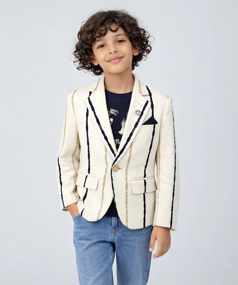 Child wearing a white blazer with black trim on a light gray background