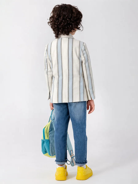 Child wearing a striped shirt and jeans with a colorful backpack on a white background