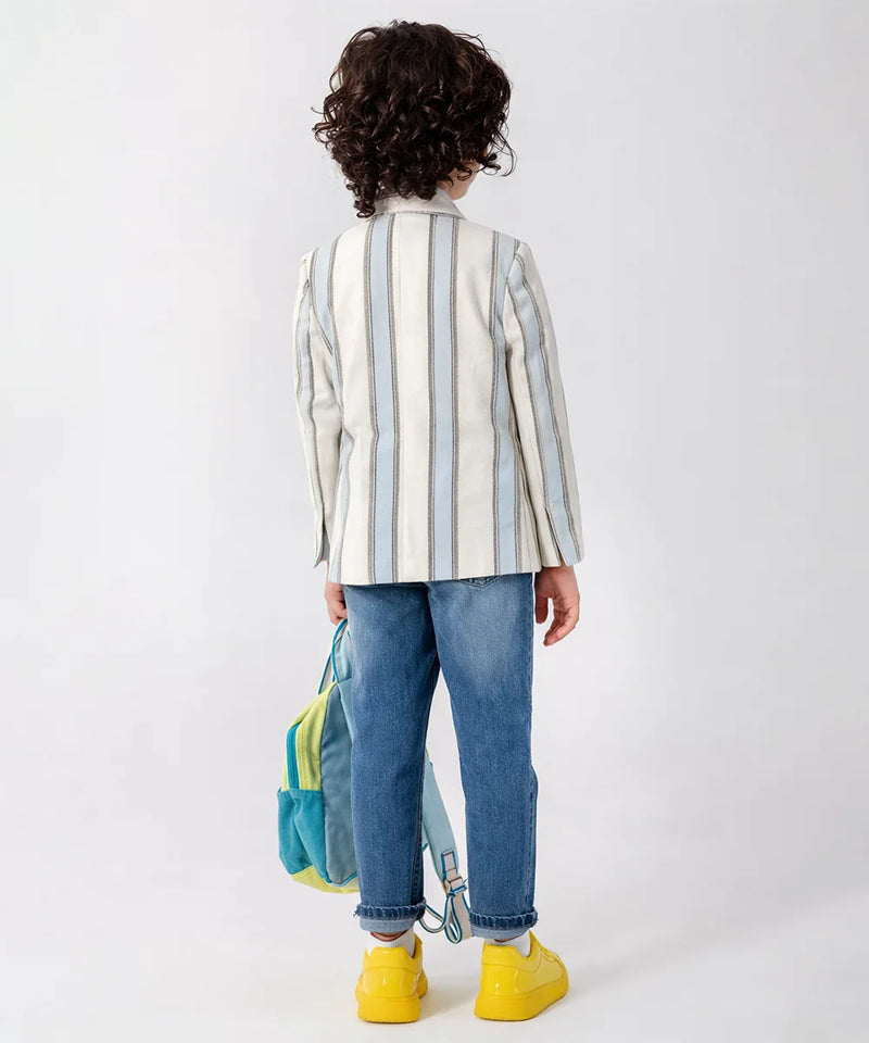 Child wearing a striped shirt and jeans with a colorful backpack on a white background