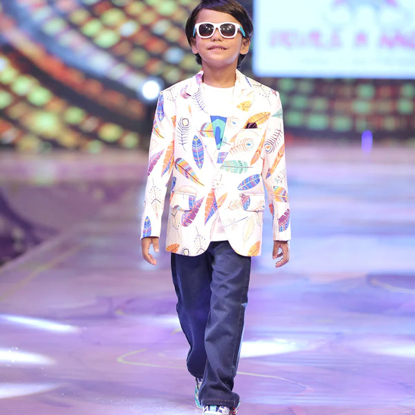 Child model walking on a fashion show runway wearing a colourful party blazer.