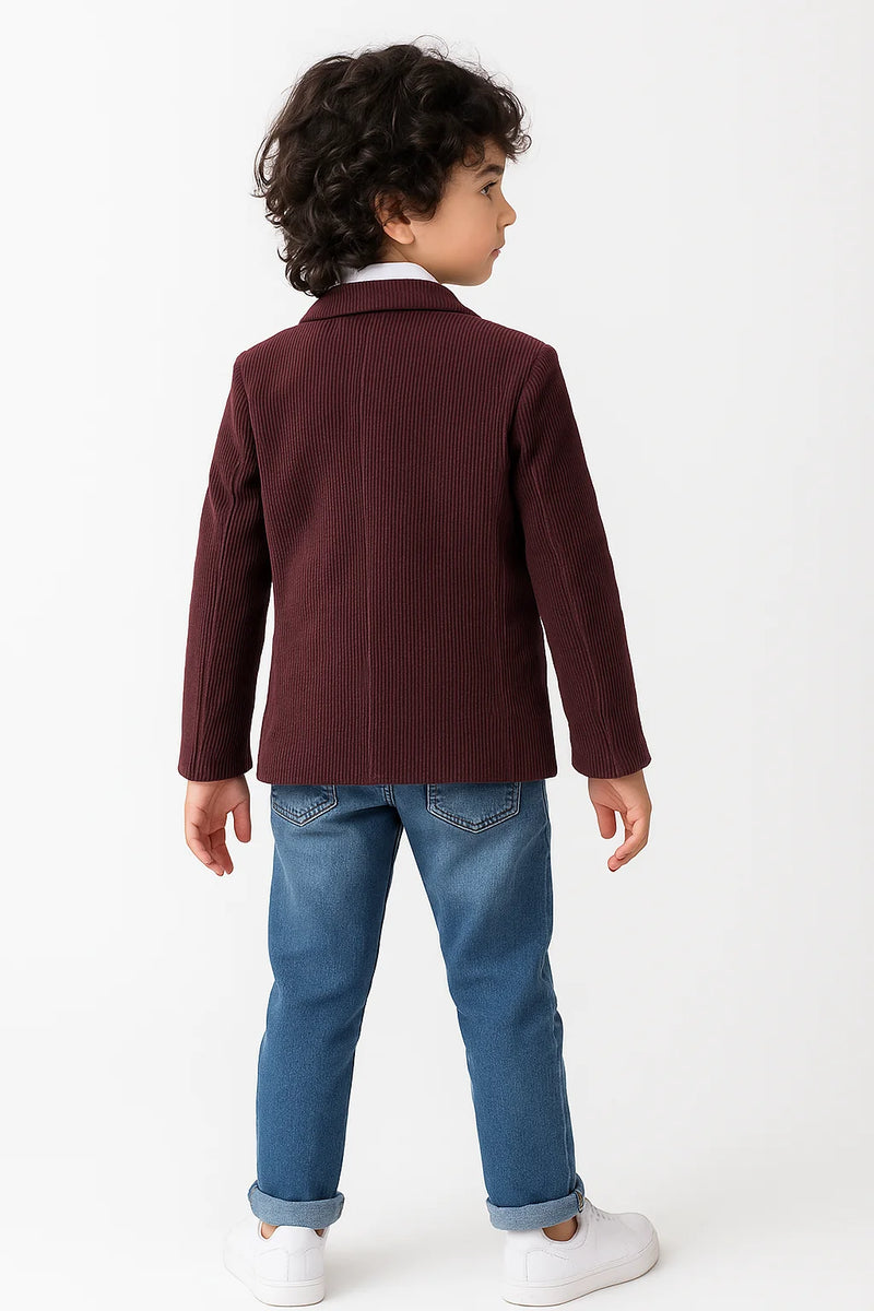 Child wearing a burgundy jacket and blue jeans on a white background