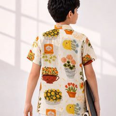 Person wearing a colorful floral shirt with a skateboard, standing against a white background