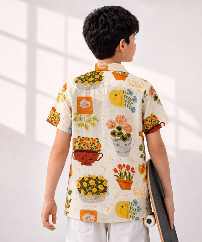 Person wearing a colorful floral shirt with a skateboard, standing against a white background
