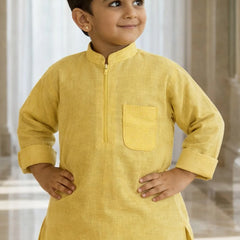 Child wearing a yellow kurta with a plain background