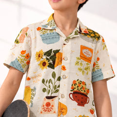 Child wearing a floral patterned shirt with a white background
