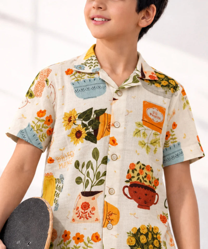 Child wearing a floral patterned shirt with a white background