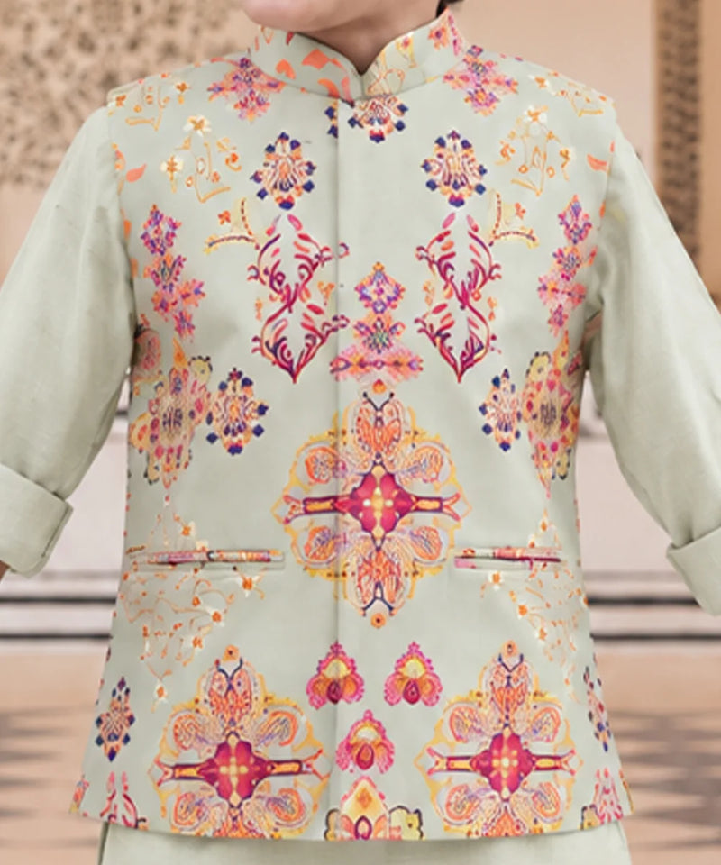 A close-up of a person wearing a light sage green traditional jacket with a vibrant, multicolored floral and geometric pattern in pink, orange, yellow, and blue.