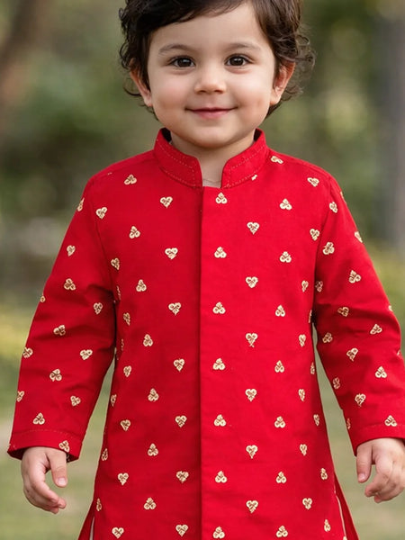 Child wearing a red outfit with heart patterns outdoors