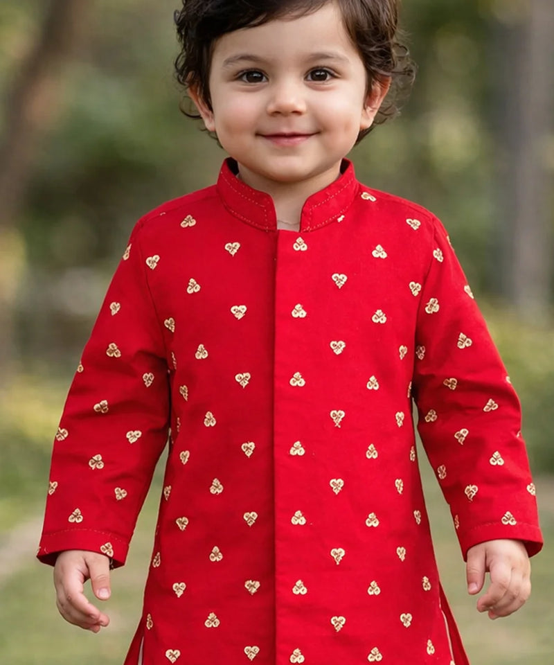 Child wearing a red outfit with heart patterns outdoors