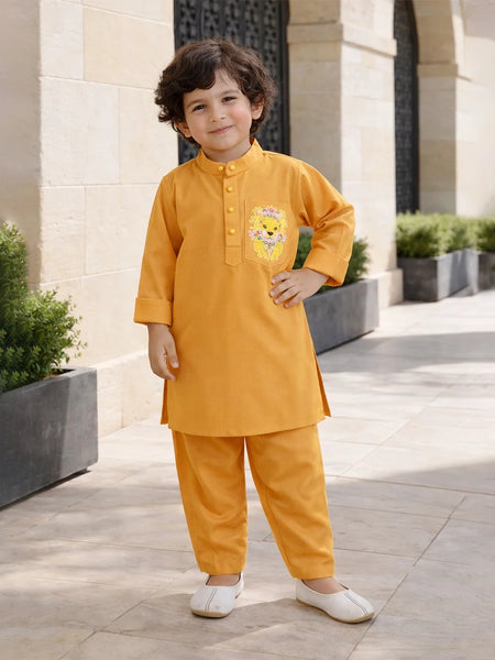 Child wearing a mustard yellow traditional outfit with a cartoon character, standing outdoors.