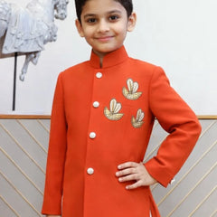 Child wearing a red traditional outfit with gold embroidery against a neutral background