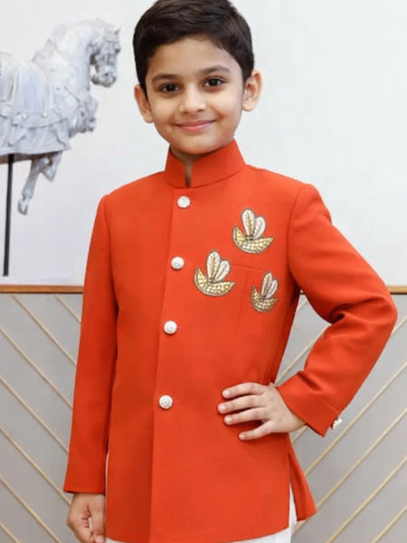 Child wearing a red traditional outfit with gold embroidery against a neutral background