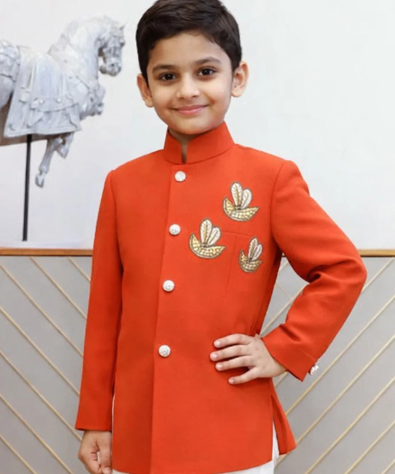 Child wearing a red traditional outfit with gold embroidery against a neutral background