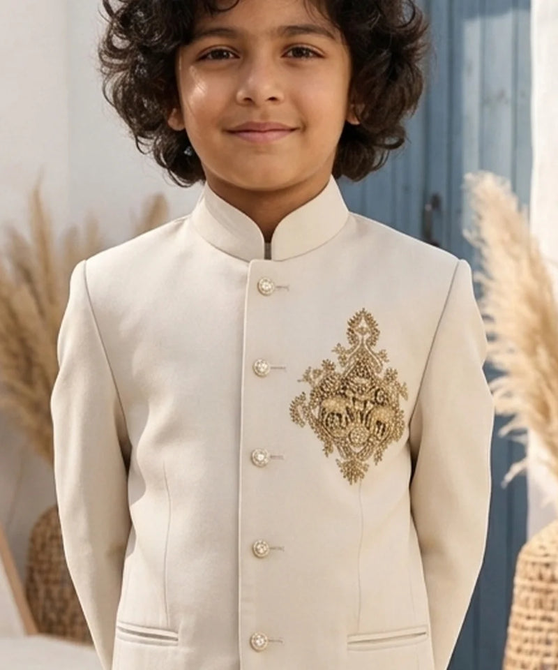 Child wearing a cream-colored embroidered traditional outfit with a blurred natural background