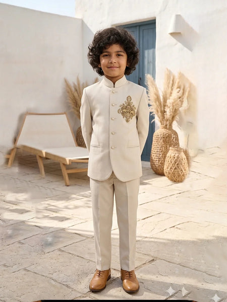 Child in a formal beige suit standing outdoors with decorative elements in the background
