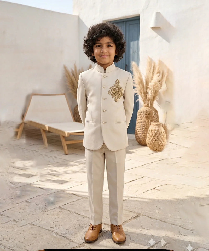 Child in a formal beige suit standing outdoors with decorative elements in the background