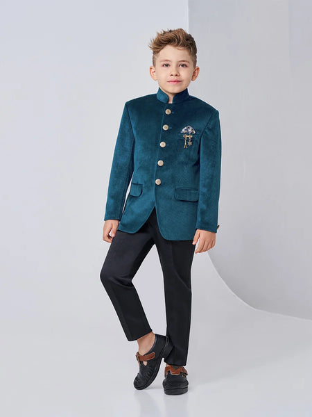 Child wearing a teal blazer with buttons and black pants on a white background