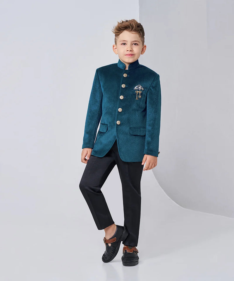 Child wearing a teal blazer with buttons and black pants on a white background