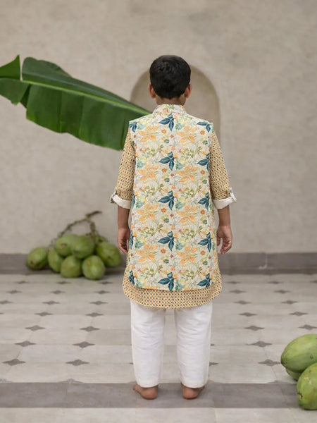 Child wearing a floral kurta with a vest in a home setting