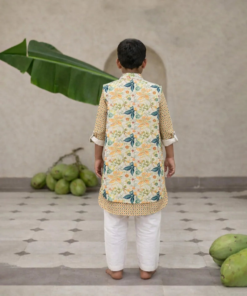 Child wearing a floral kurta with a vest in a home setting