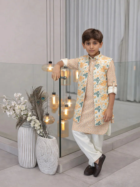 Young boy in traditional outfit standing indoors with decorative elements.