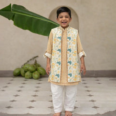 Child wearing a traditional outfit with a floral pattern in a room with a plant and fruit.