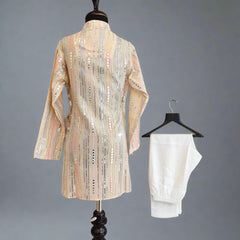 Mannequin wearing a patterned dress with a white garment on a hanger against a gray background