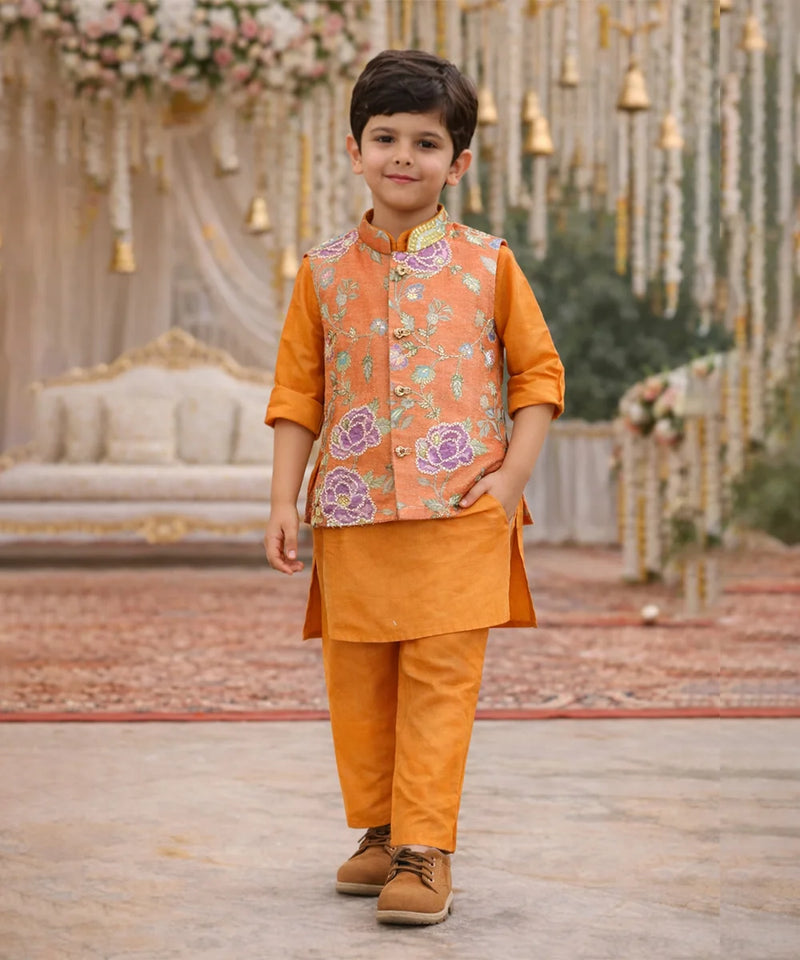 Child wearing an orange traditional outfit with a floral vest in a decorated setting