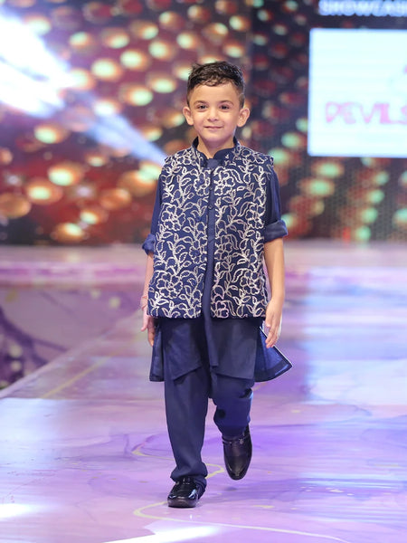 Child model walking on a fashion show runway wearing a shimmer jacking and navy blue color kurta pyjama traditional outfit.