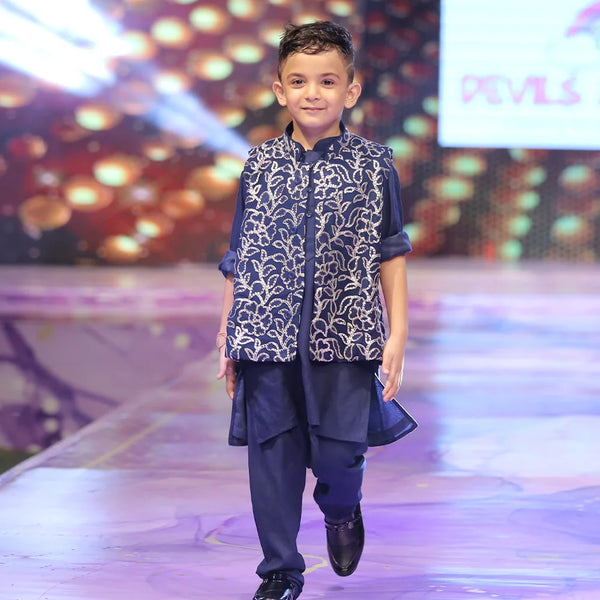 Child model walking on a fashion show runway wearing a shimmer jacking and navy blue color kurta pyjama traditional outfit.