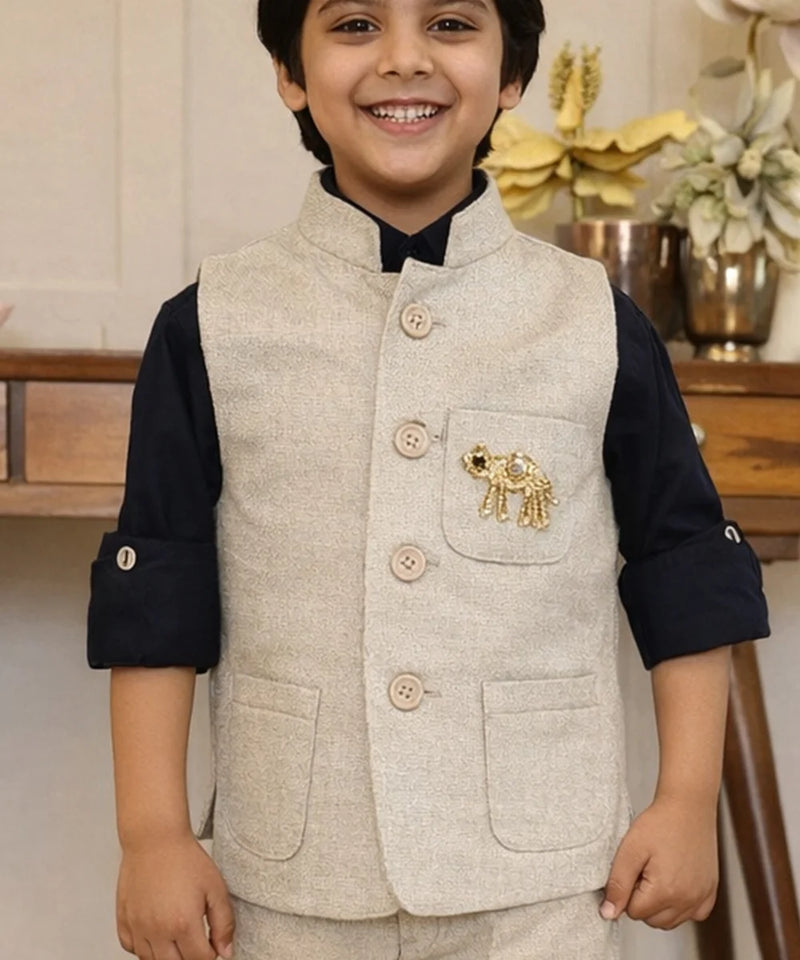 Child wearing a beige vest with an elephant emblem indoors