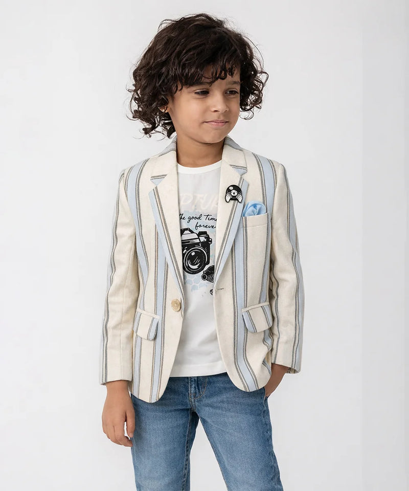 Child wearing a striped blazer over a graphic t-shirt with jeans on a white background