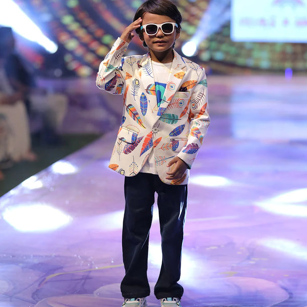 Child model on a fashion show runway wearing a colorful printed blazer